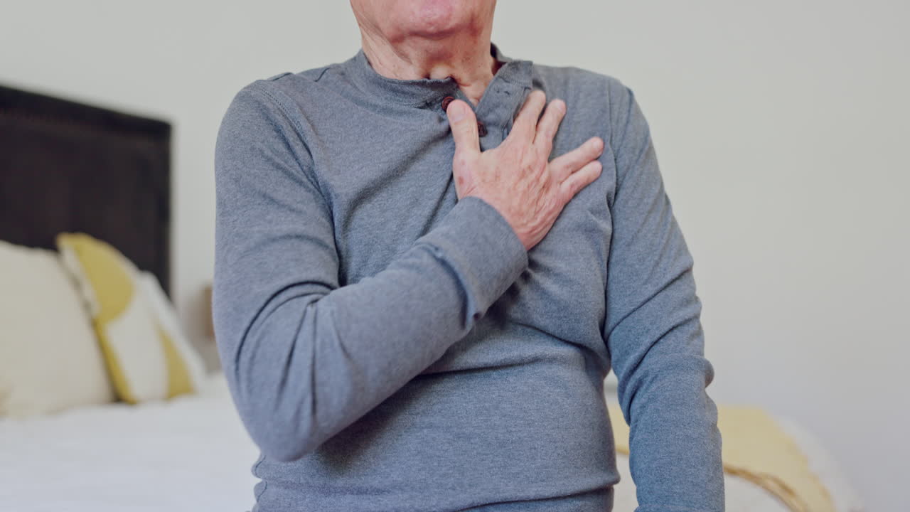 hombre maduro y manos con dolor en el pecho en el dormitorio