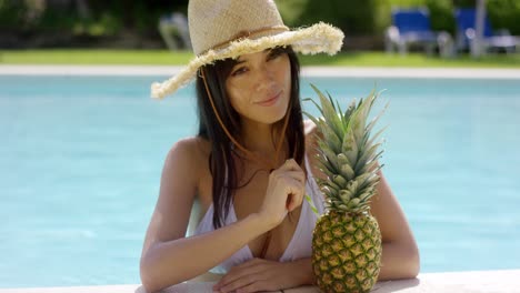 sunbathing beauty drinks from a pineapple