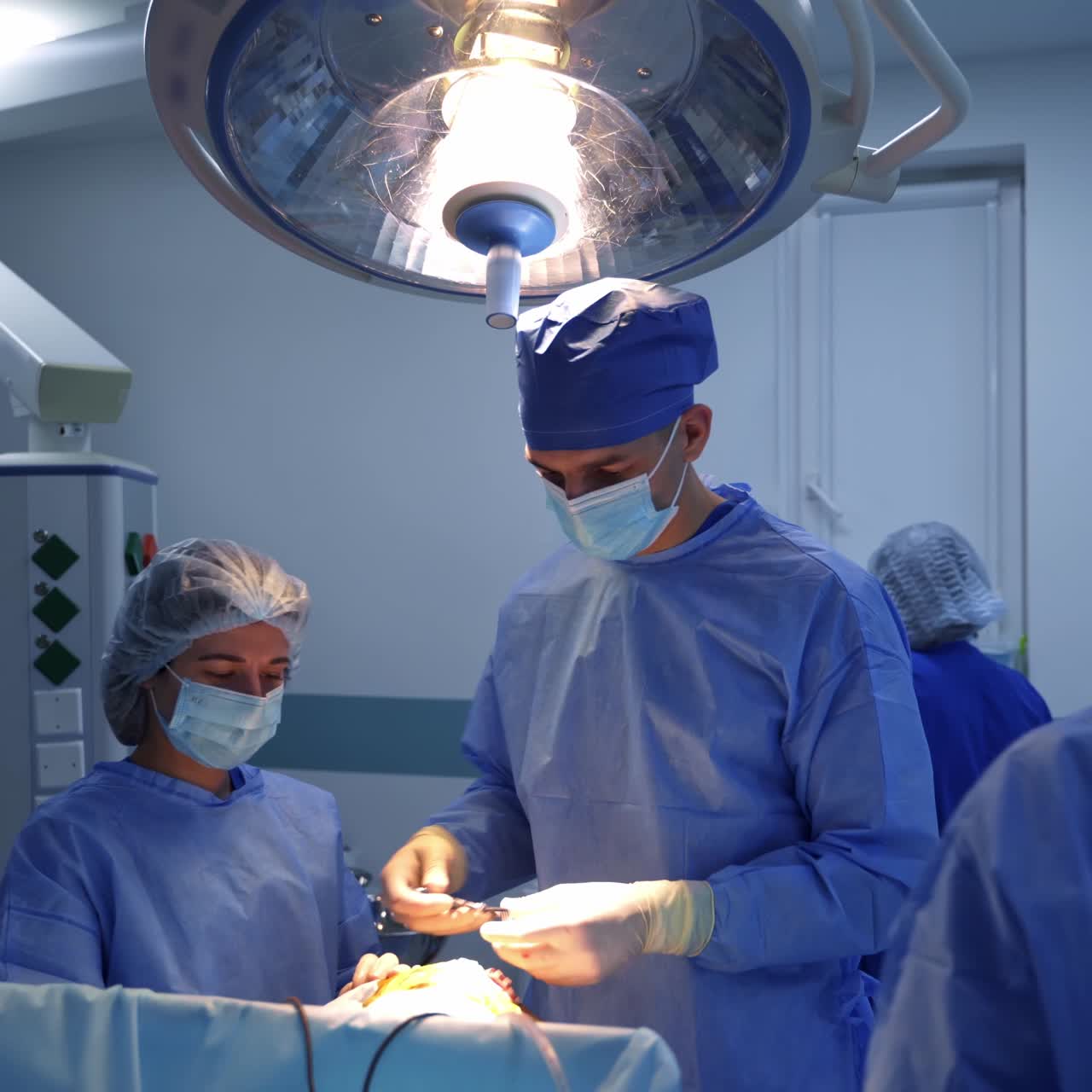 Professional surgeons in medical unifrom and mask perfoming operation. Neurosurgeon specialist team working in emergency room