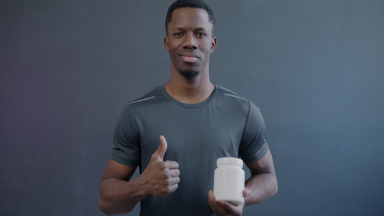 Man holding a supplement bottle and giving a thumbs up