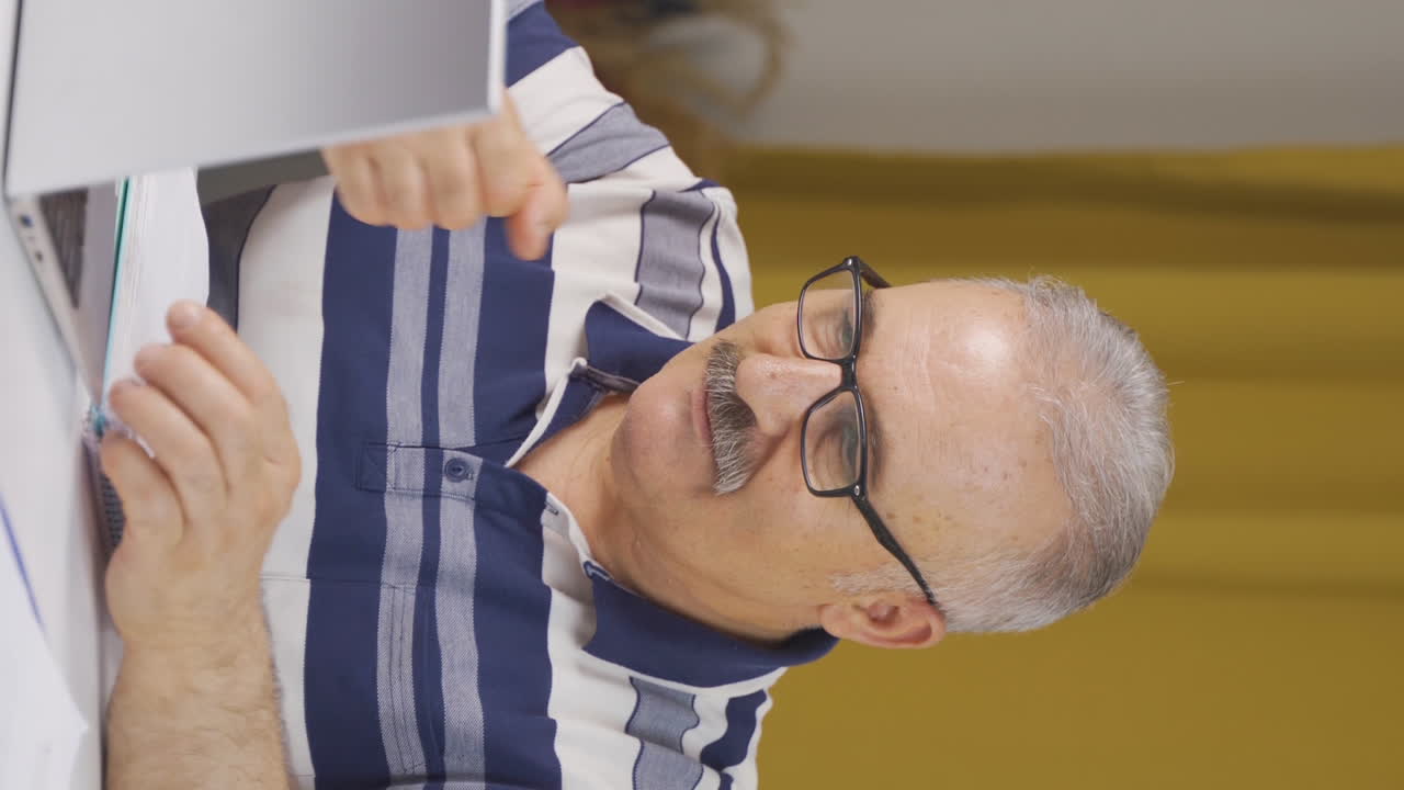 vídeo vertical del retrato ambicioso y determinado de un anciano trabajador de la oficina en casa.