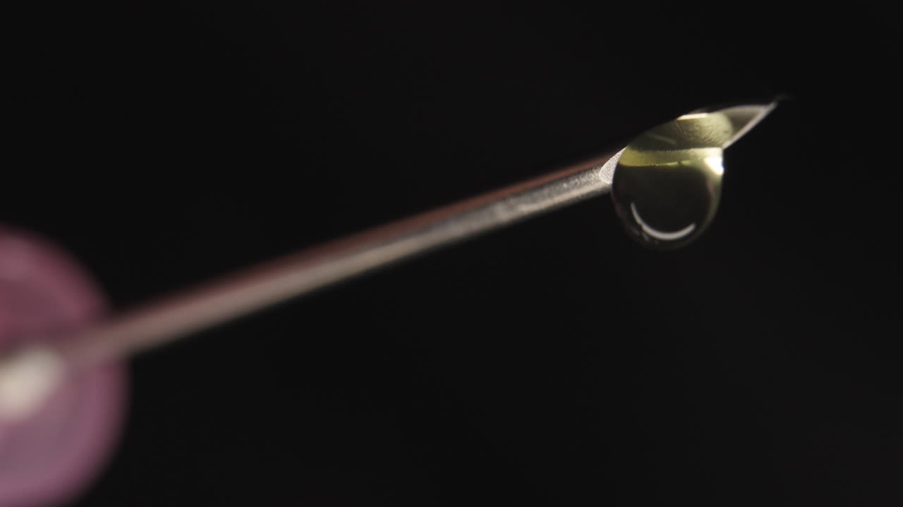 primer plano en ángulo bajo de goteo de la punta de la jeringa