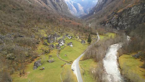 drone moving from the left to the right side of the frame, showing the stone house of cavergno village and river maggia, located in the district of vallemaggia, a canton of ticino, in switzerland