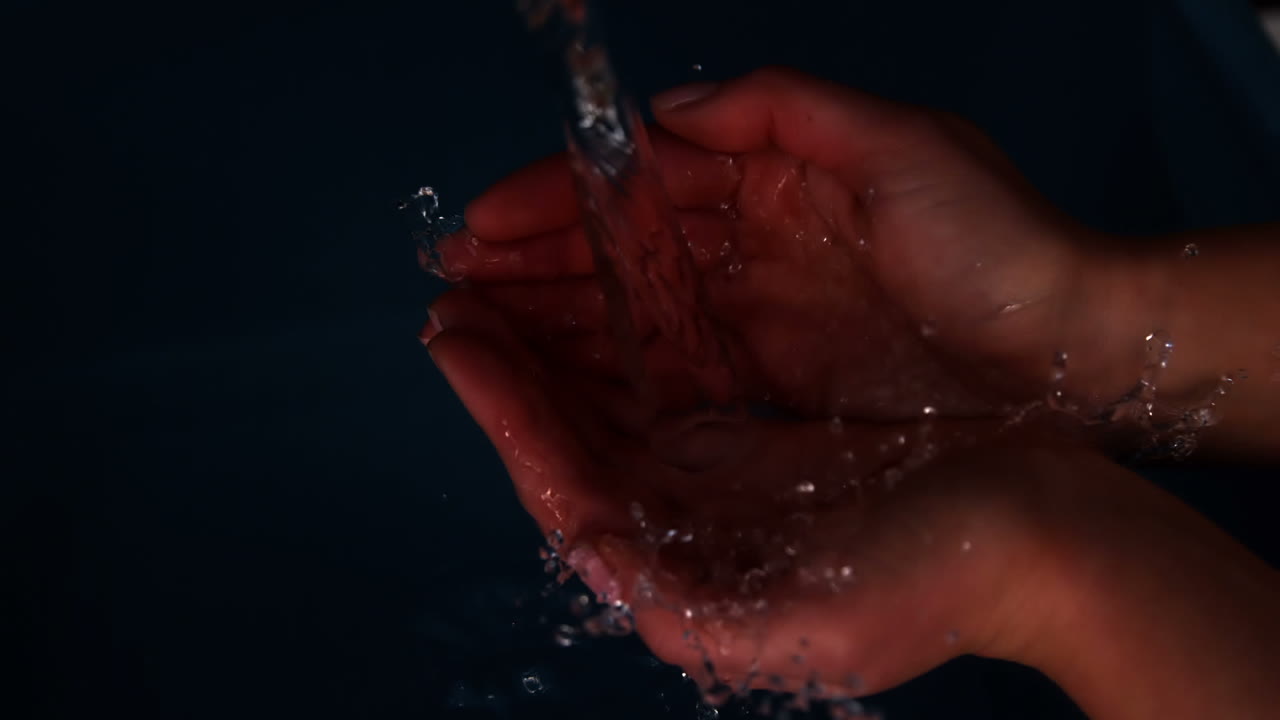 manos sumergiéndose en el agua negra