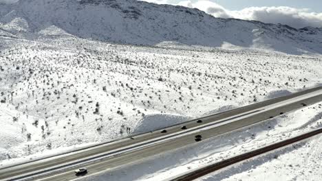 highway through snow covered mountainside, aerial side truck view