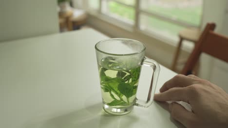 Hand-tapping-on-table-as-if-waiting-while-mint-tea-is-on-the-table