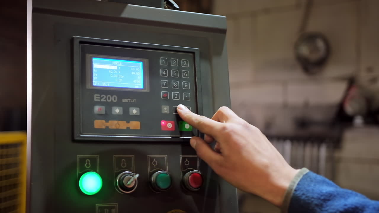 Hand pushing the button on factory panel. Side view of male hand pushes the control panel buttons during a factory workflow. Industry indoors.Close-up.