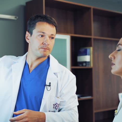 professional male doctor speaks with a female specialist in a hospital. close-up faces of doctors talking in the room together. medical concept.