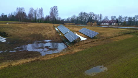 Orbit-aerial-shot-of-solar-panels-place-alongside-fertile-field-posing-innovative-energy-source-in-rural-area