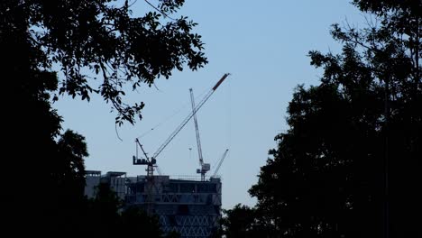 camera zooms out revealing this silhouette scenario of cranes and construction, bangkok, thailand