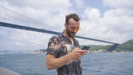 Joven-Usando-El-Teléfono-Junto-Al-Mar.