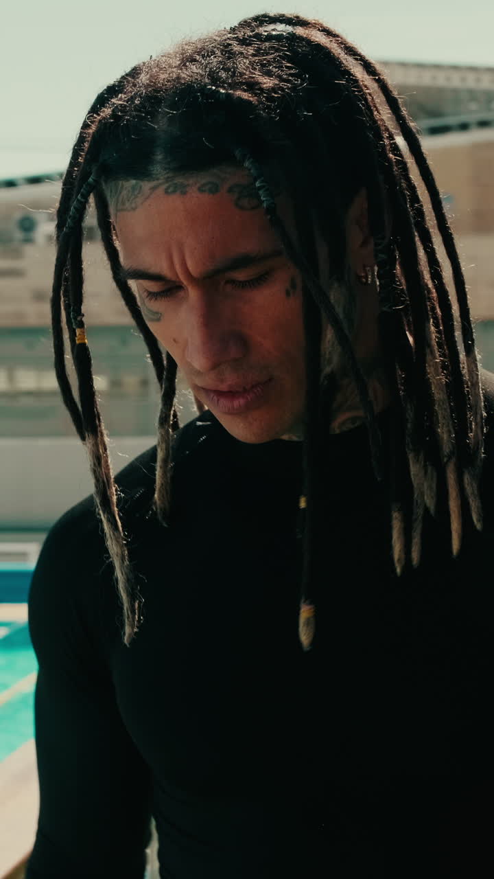 Uomo con dreadlocks e tatuaggi