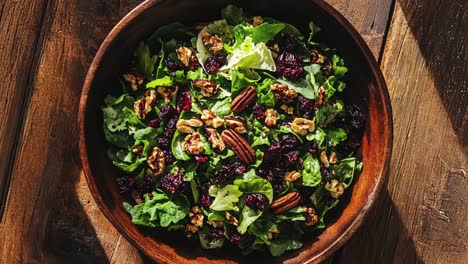 closeup of a delicious salad with cranberries, walnuts, and pecans in a wooden bowl