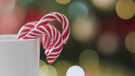 video de taza blanca con bastones de navidad y luces de árbol de navidad con espacio de copia