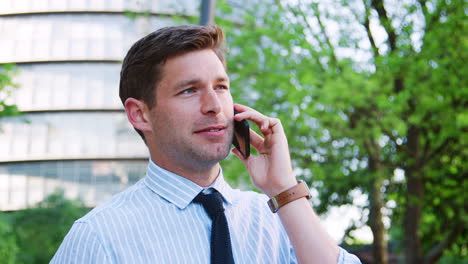 Businessman-Talking-On-Mobile-Phone-Outside-Office