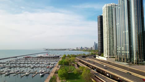 cars passing water front modern luxurious buildings drone in chicago