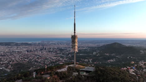 torre de comunicaciones torre de collserola al atardecer en el tibidabo con la ciudad de barcelona en el fondo, españa