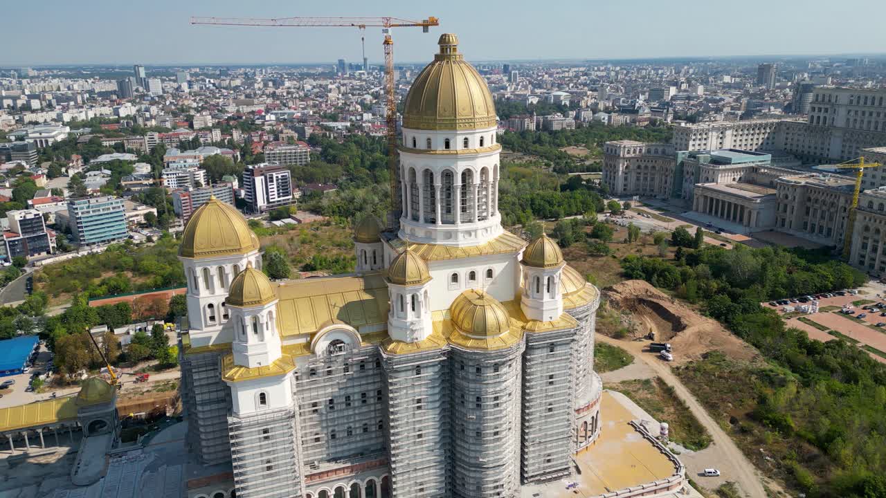 People's Salvation Cathedral aerial perspective. Drone circling arround the Cathedral. Building still under construction. In background is the Palace of Parliament. Travel destination.