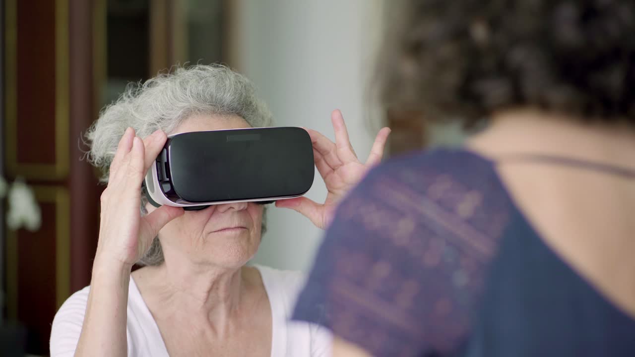 Concentrated senior woman adjusting VR headset.