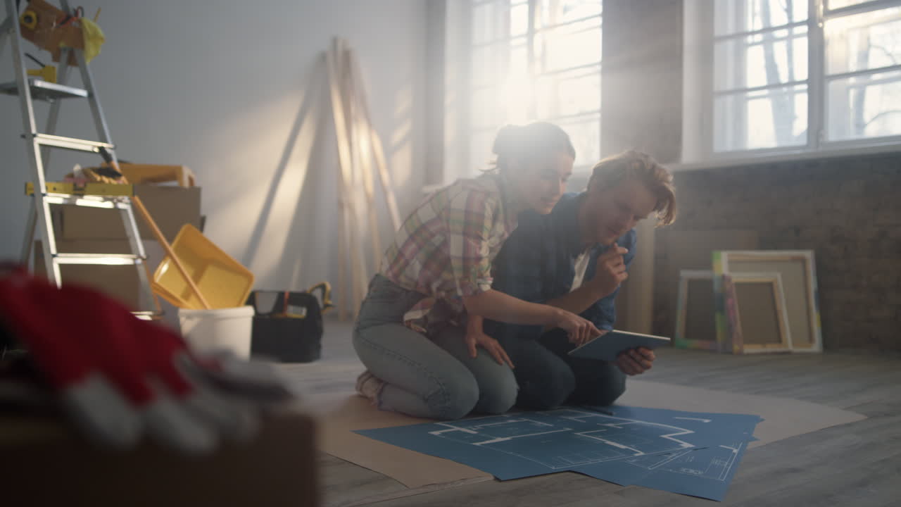 Geconcentreerde vrouw legt huisreparatie uit aan de hand van een schema. Stel bespreekt renovatie.