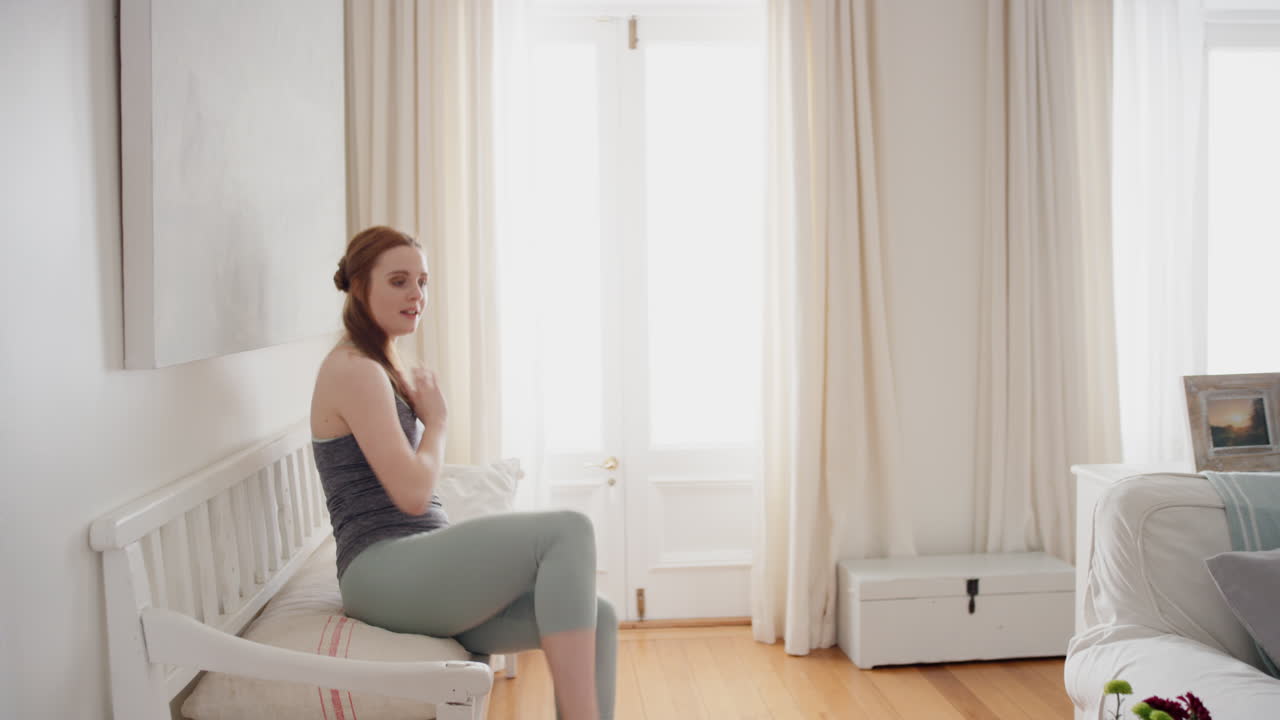 행복한 젊은 여성이 집에서 춤을 추고  ⁇ 키 댄스 동작으로 축하하고 자유를 즐기고 주말에 재미를 느끼고 있습니다.