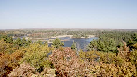 Au-Sable-River-in-Michigan-during-fall-colors-with-drone-video-moving-forward-over-trees