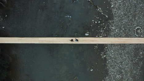 young couple dancing and enjoying each other over a suspension bridge over a river