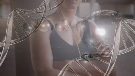 animación de cadena de adn y manchas de luz sobre mujer biracial haciendo ejercicio.