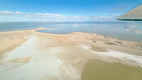 aerial footage captured from a cessna aircraft over lake eyre in the south australian outback. witness the beautiful sight of this salt lake filling with water, reflecting the serene blue sky.