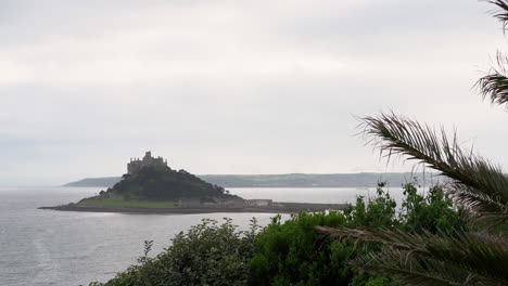 view from a terrace in marazion of the english medieval castle and church of st michael's mount in cornwall on a cloudy spring day