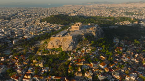 toma aérea en círculo de la acrópolis con la ciudad vieja de atenas en primer plano al amanecer