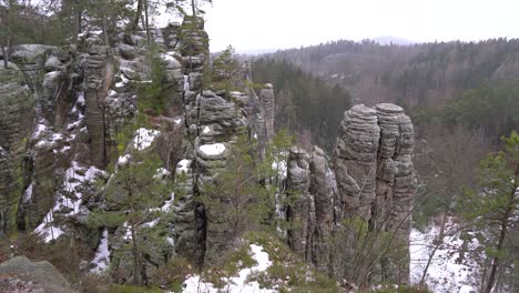 sandstone rock formation with snow and landscape in prachov rocks, bohemian paradise, tilt up