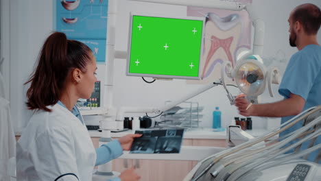 dentist looking at monitor with horizontal green screen