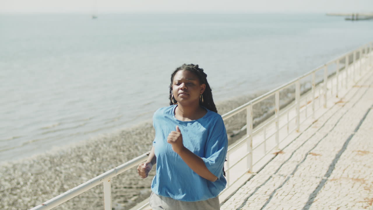 Handheld shot of woman running well within herself in park