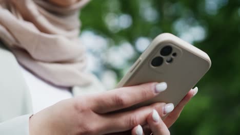 Close-up-of-unrecognizable-woman-with-a-hijab-using-her-phone,-Arab-girl-using-a-smartphone