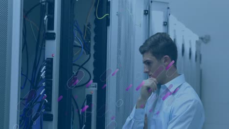 Animation-of-shapes-over-caucasian-male-worker-inspecting-server-room