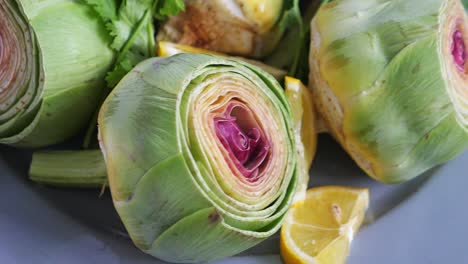 primer plano de alcachofas cocidas con limón y cilantro