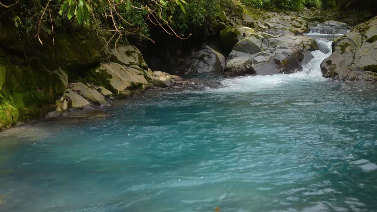 río azul con agua cristalina entre rocas en la selva tropical de costa rica con agua azul