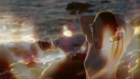 standing on rocky beach, woman with sunlight creating animation lens flare effects