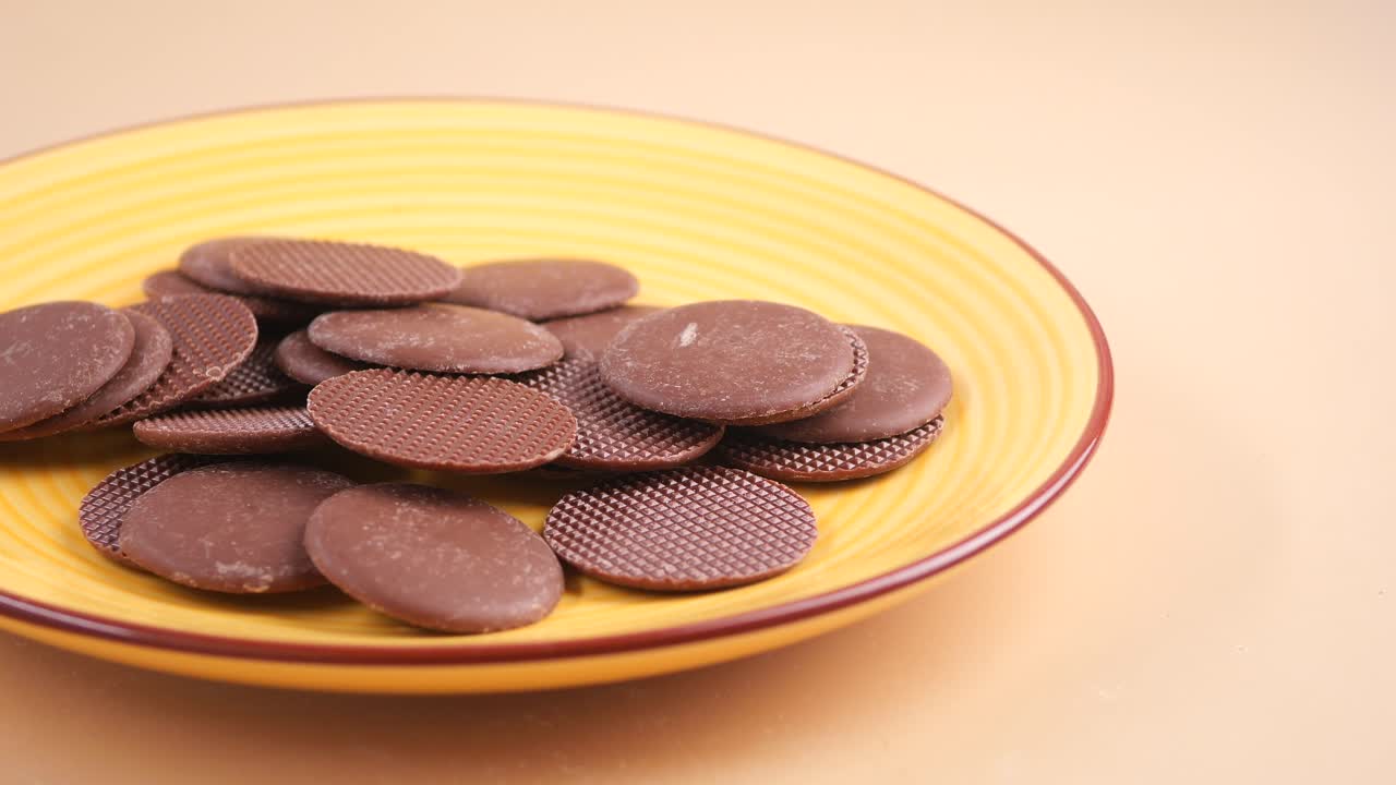 Cialde rotonde al cioccolato su un piatto giallo