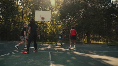 young men playing basketball outdoors