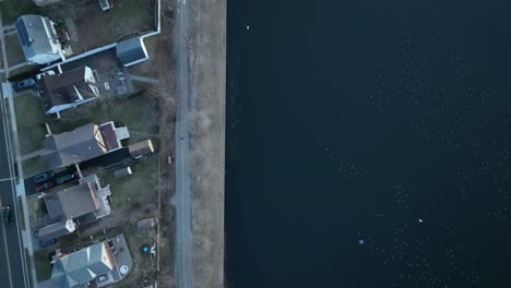 an aerial shot directly over a green pond in a suburban neighborhood on long island, ny