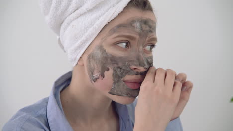 portrait of woman removing facial mask