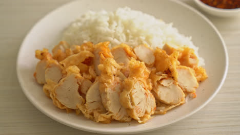 fried chicken topped on rice with spicy dipping sauce