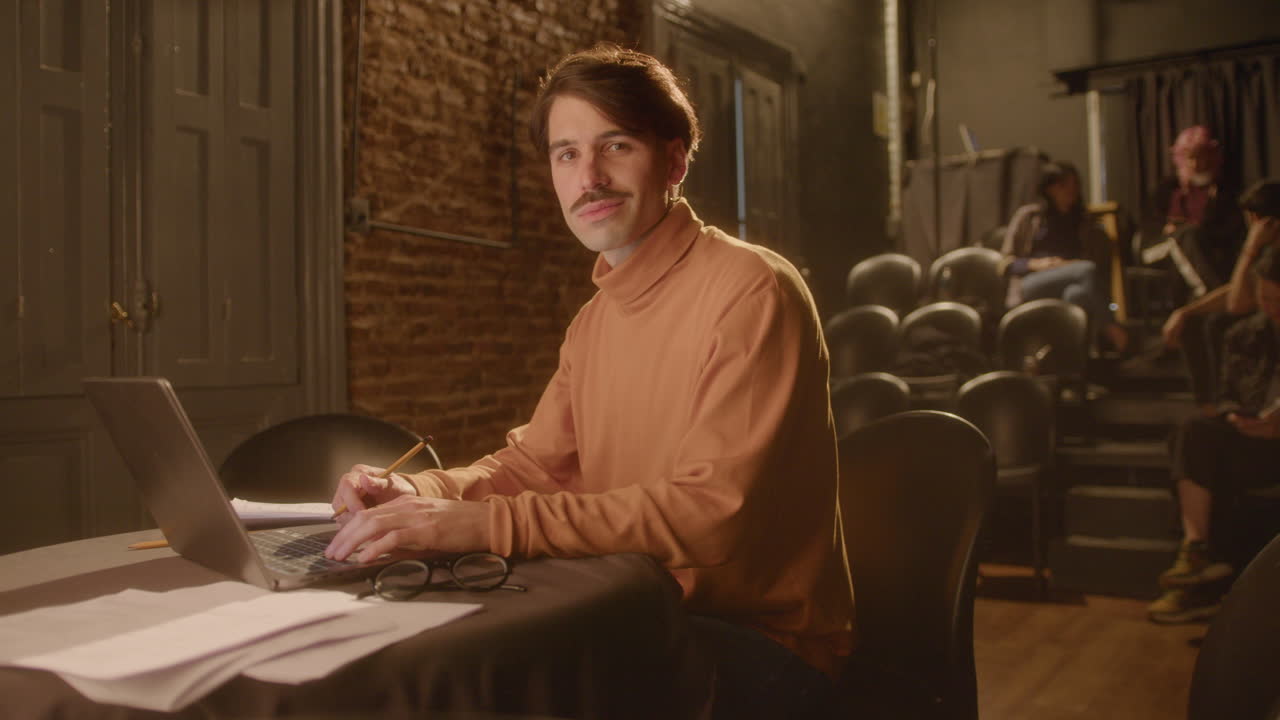 Portrait of Playwright with Laptop and Papers on Theater Stage