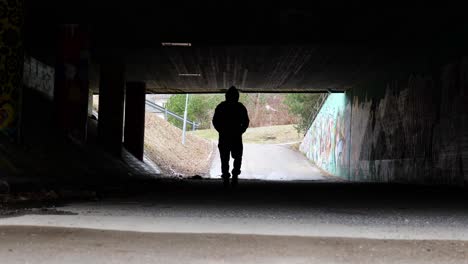 Silhouette-Eines-Mannes,-Der-Allein-Durch-Einen-Tunnel-Geht