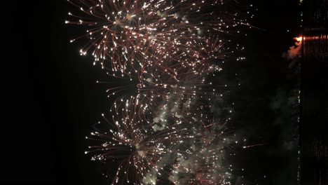 Alternating-explosions-of-colorful-lights-bursting-in-the-night-sky-in-front-of-a-beach-in-a-famous-tourist-district-in-a-Southeast-Asian-country