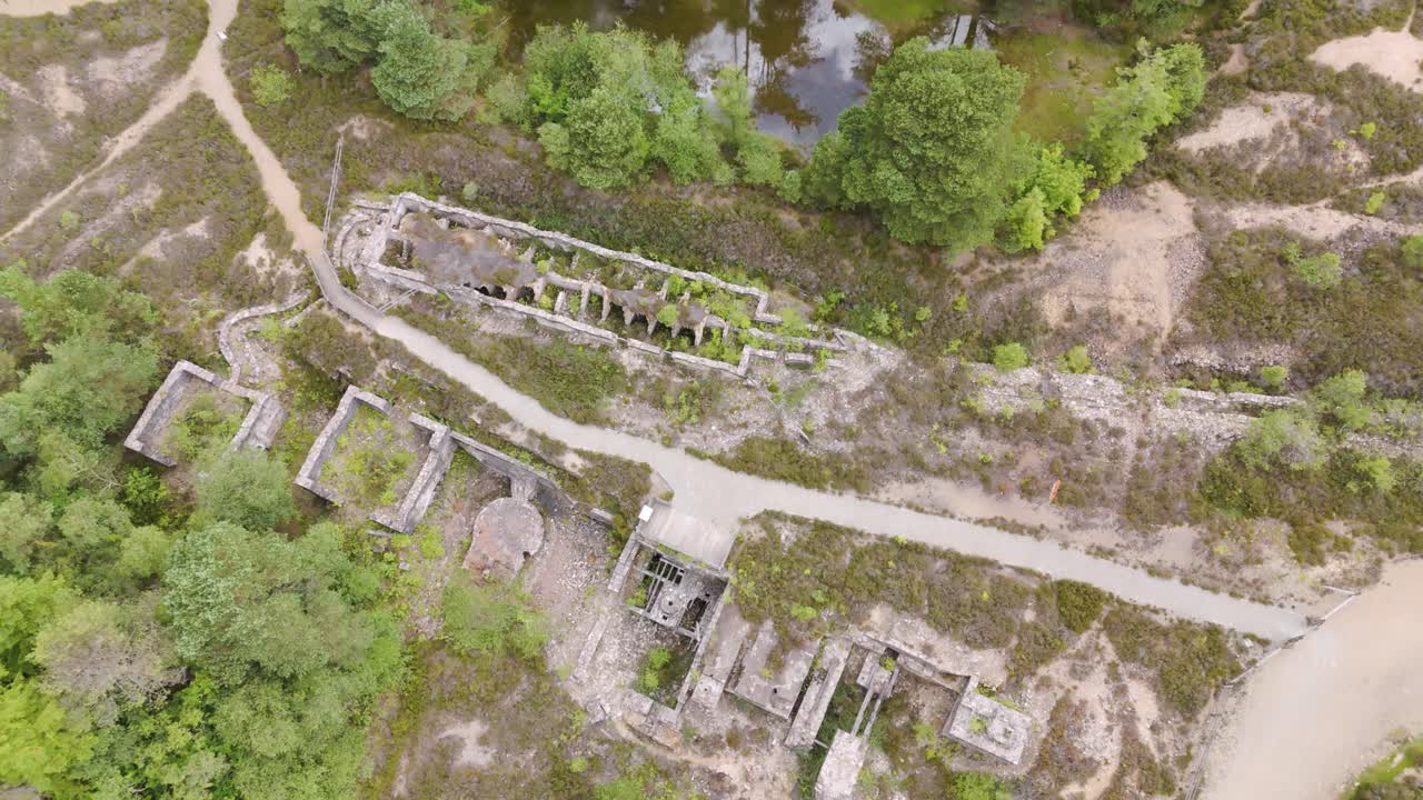 Aerial orbital view of mining ruins from the industrial revolution, surrounded by natural vegetation, Cornwall, UK