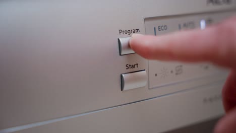 man hand starting dishwasher