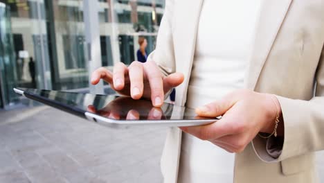 mujer de negocios usando una tableta digital en el edificio de oficinas
